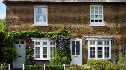 building with white door and windows and flowers